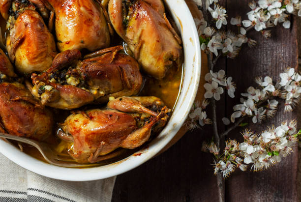istock Baked quail stuffed with mushrooms, eggs and bread in a ceramic form on a wooden table. 2068639907