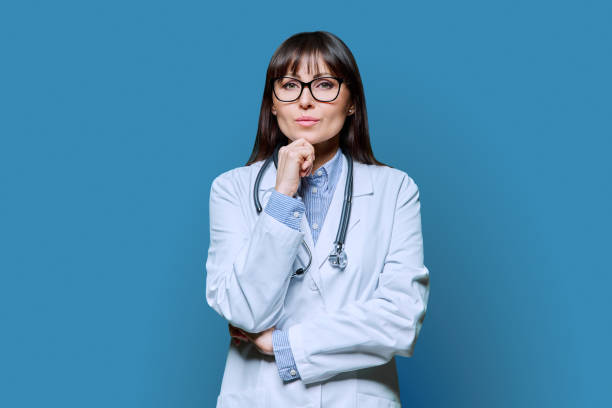 istock Confident serious female doctor looking at camera on blue background 2068678799