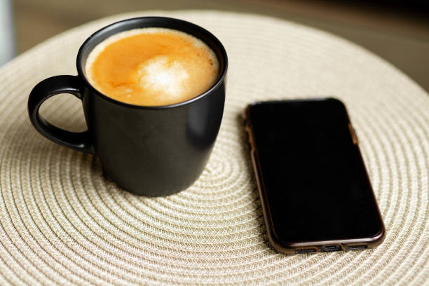 iPhoneとテーブルの上のコーヒー