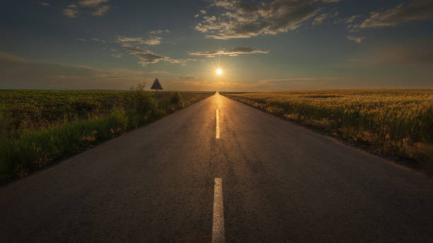 istock An empty road against the setting sun at beauttiful sunset 2068729307