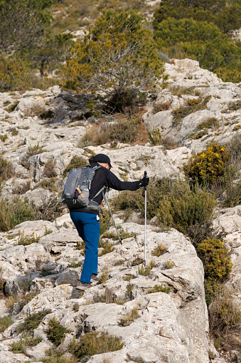 Alcoy, Spain, 07/03/2024: Octogenarian person hiking in the Alt de les Pedreres in Alcoy, Spain