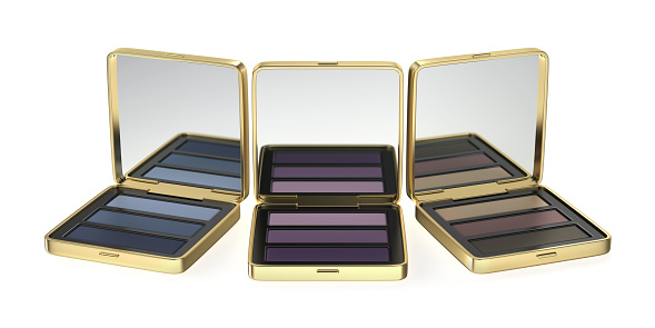 Compact eyeshadow palettes in gold boxes on white background