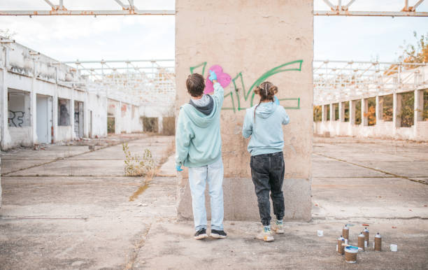 istock Back view of two best friends drawing graffiti and creating their art 2068799962
