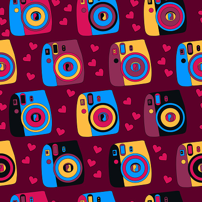 Colorful photo cameras seamless pattern whit hearts on a dark red background.