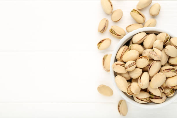 istock Pistachios in bowl on white wooden table 2068825920