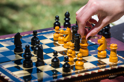 Woman's hand moving chess pieces