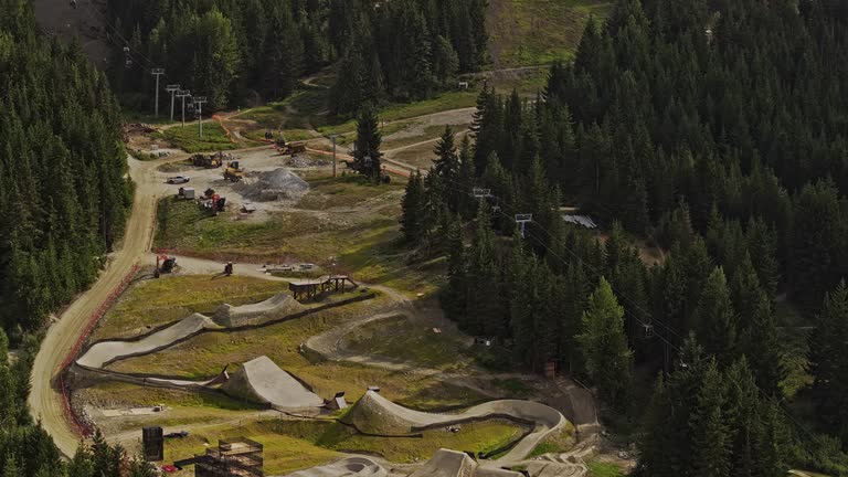 Whistler BC Canada Aerial v14 zoomed flyover downhill slopes capturing mountain bike park trails and uphill chairlift ride surrounded by lush coniferous forest - Shot with Mavic 3 Pro Cine - July 2023