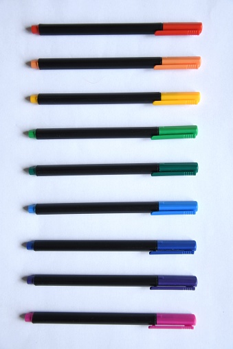 Overhead photo of colorful pens on white background
