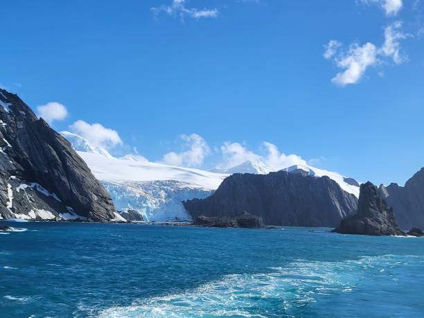 istock Bright blue ocean in Antarctica, Elephant island, snow covered cliffs, huge glaciers on a bright sunny day, blue sky and white clouds, icebergs floating 2068914699