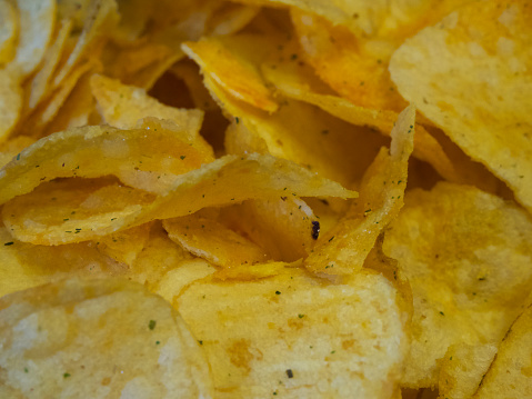 Spiced potato chips, a close-up shot. Fried potatoes.