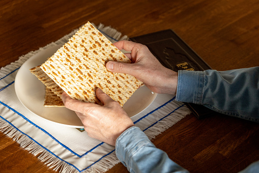 A man celebrates the Jewish holiday of Passover. holding matzo in his hands