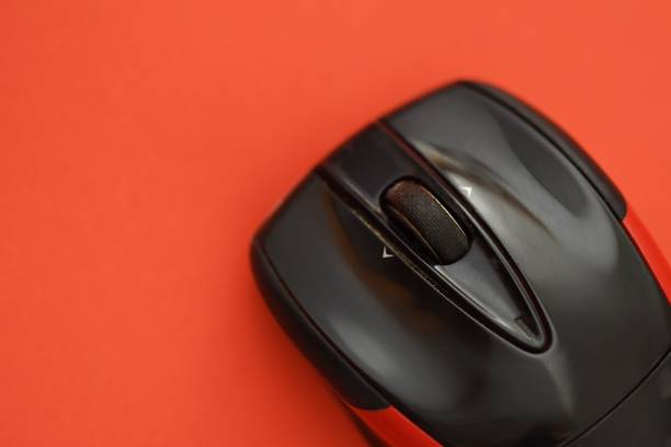 Photo of a black and red computer mouse on a red background
