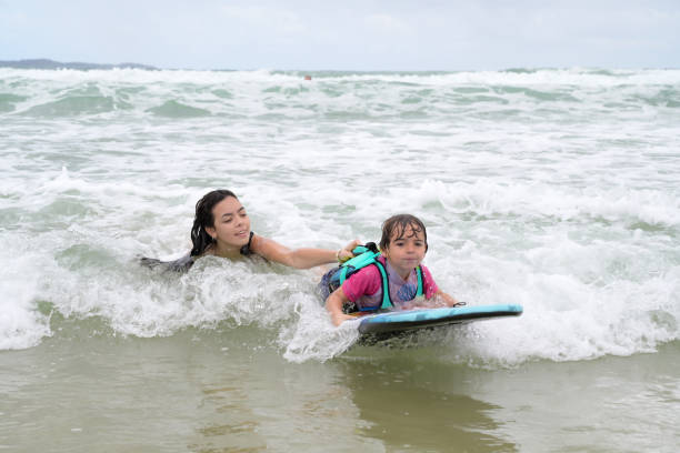 istock brothers playing with surfboard in the waves on the shore 2069022769