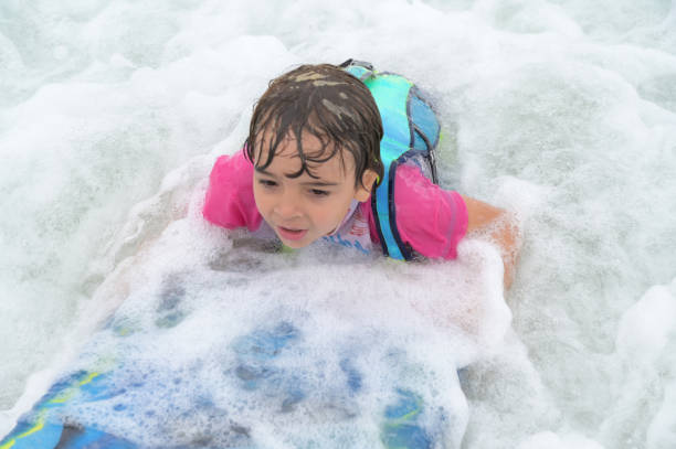 istock brothers playing with surfboard in the waves on the shore 2069024326