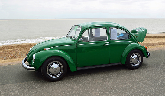 Felixstowe, Suffolk, England -  May 07, 2017: Classic Green  VW Beetle Motor Car Parked on Seafront Promenade.