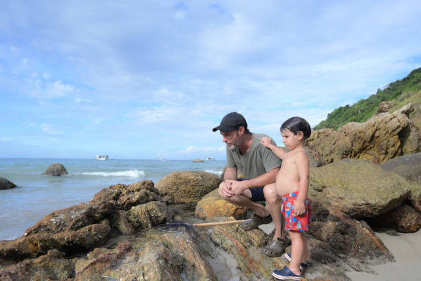 father with son on rocky coast