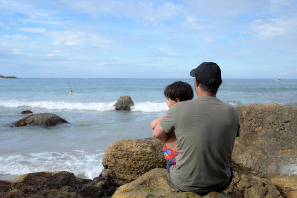 father with son on rocky shore