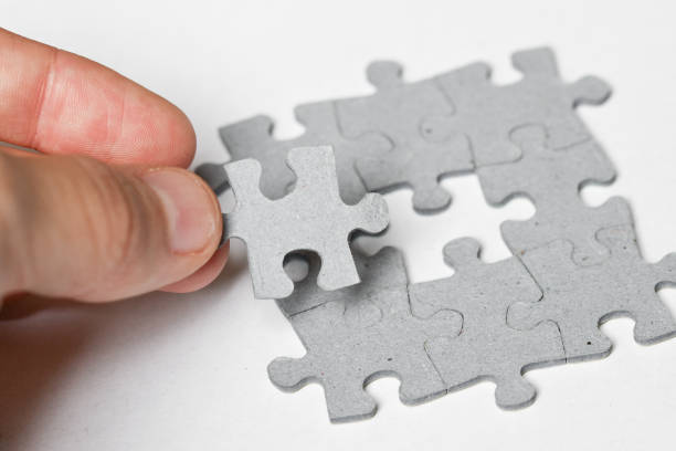 istock Person adding last piece of jigsaw puzzle 2069051063