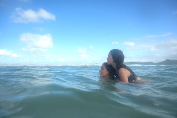 istock sisters having fun in the sea water 2069056949