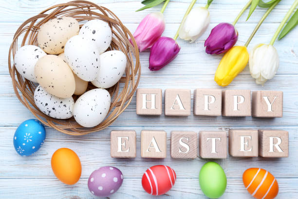 istock Wooden cubes with painted eggs and tulips on wooden table 2069059115