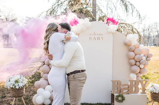 It's a girl! During the gender reveal party, the parents-to-be rejoice as they find out they are expecting a girl. Pink smoke can be seen behind them