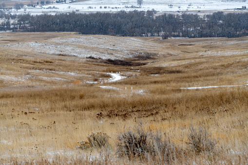 Little Bighorn Battlefield National Monument in winter in southeastern Montana, in western USA of North America. Commemorates the Battle of the Little Big Horn which took place in June 1876. The Little Big Horn river runs across the top of the photo. It is lined with trees.