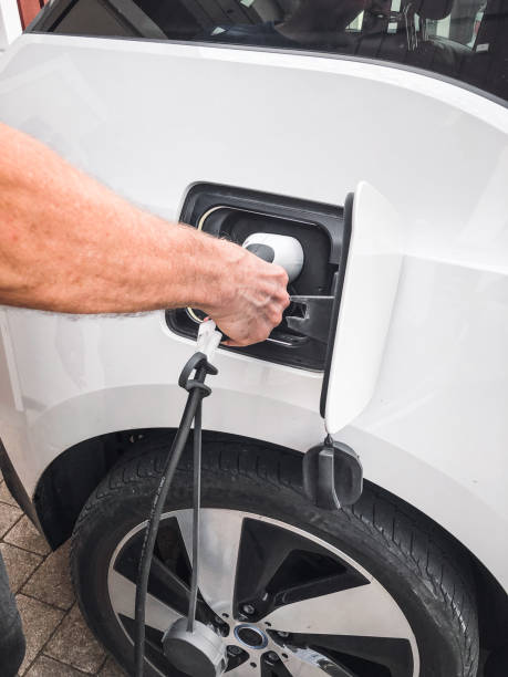 istock Man putting charging cable into electric car 2069087476