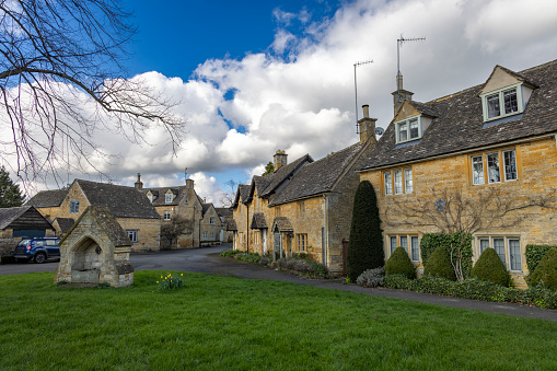 An image of Lower Slaughter, a captivating village in the heart of the Cotswolds, showcasing its timeless beauty with the River Eye meandering through. This peaceful village is framed by traditional Cotswold stone cottages and lush greenery, epitomising the quintessential English countryside charm. It's also famous for it's old mill.