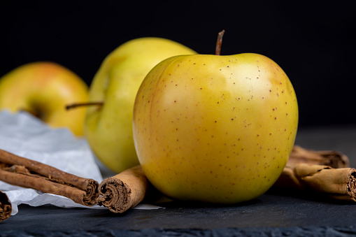 yellow ripe apple with cinnamon on the table, cooking ingredients
