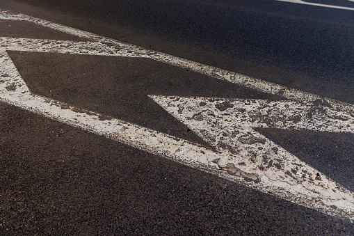 old road markings on the highway in winter, old paved road with white lines to streamline traffic