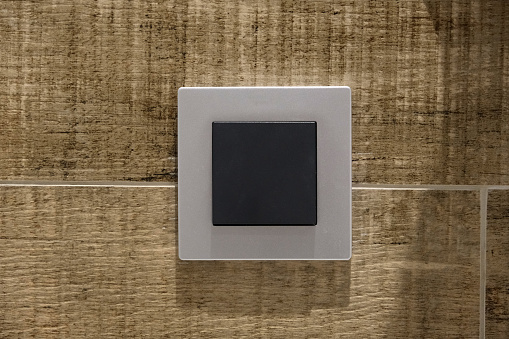 gray switch with black keys on the wall