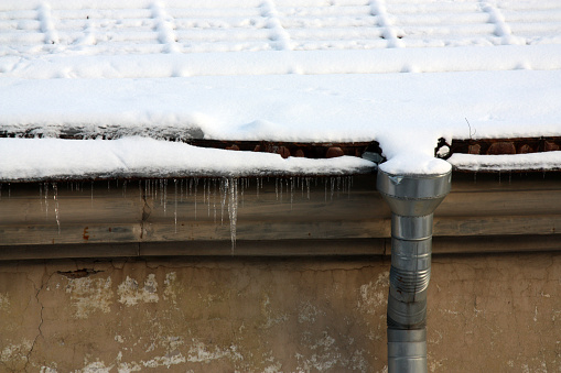 roof with snow and metal rod for rainwater