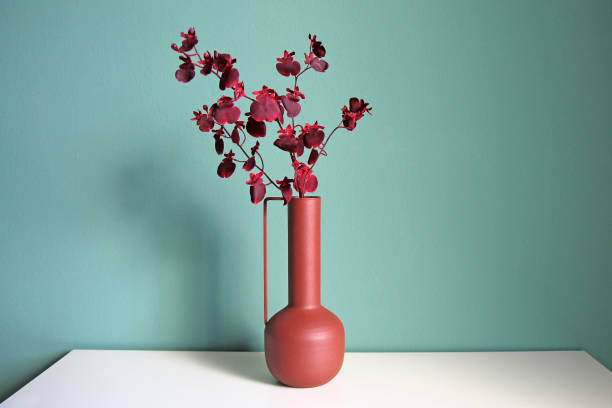 Blooming branch in a modern ceramic vase on a white table. Oriental style design. stock photo