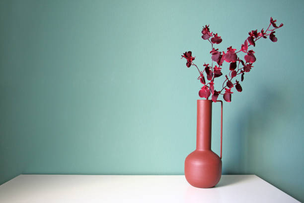 Blooming branch in a modern ceramic vase on a white table. Oriental style design. stock photo