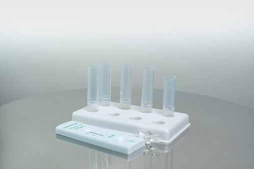 Rapid antigen Covid 19 test at home with self testing kit by placing nasal or mouth swab specimen inside the extraction buffer tube with reagents liquid. For in vitro diagnostic use only.