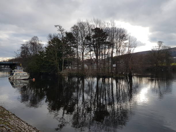 a yatch or a boat, a small island and reflection of trees on water, balloch, loch lomond 글래스고 스코틀랜드 영국 - central pier 뉴스 사진 이미지