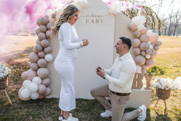 istock Young man kneels down and proposes to his smiling girlfriend 2069205336