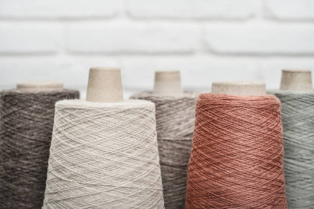 Set of colored yarn for knitting on cone on light background,  with copy space