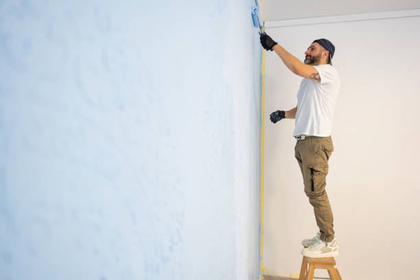 istock Caucasian handyman paint the wall with light blue paint 2069226256