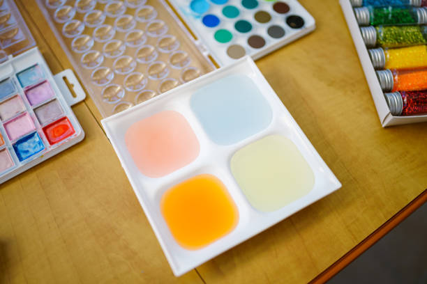 Pastel watercolor painting materials sitting on a wood table at home during a leisure and relaxing weekend day at home.