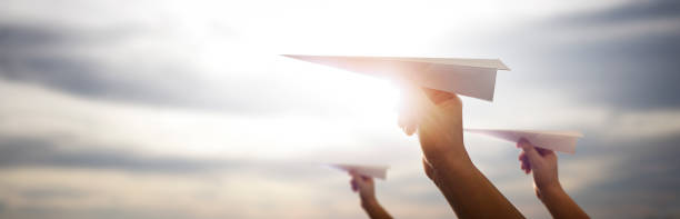 Men about to launch paper airplanes on a beautiful afternoon