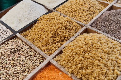 Variety organic groats in box on sale on a farmers market, ecological cereal products,pasta, fava beans, lentils. Food background. Traditional arabic market.