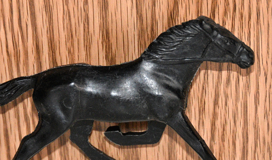 Antique plastic running horse on the shelf.