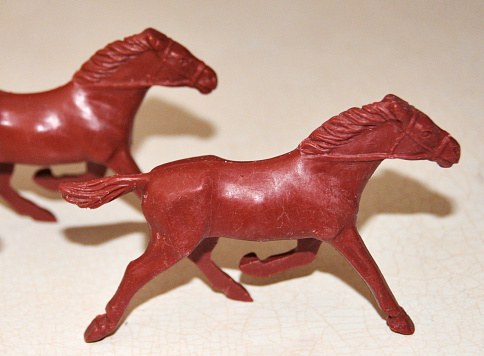 Two vintage plastic toy horses on the countertop.