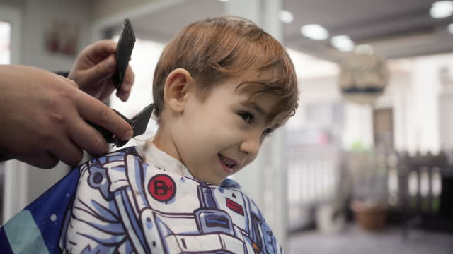 Child boy having a haircut at the barber shop