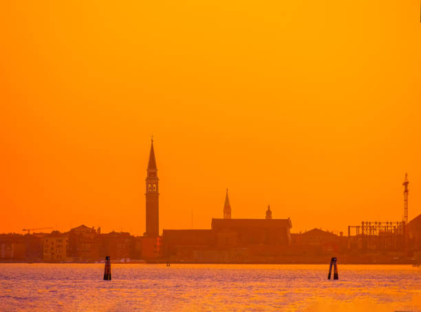 Venice, Italy. 29 october 2022. silhouettes of Venice at sunset in the bright warm orange-red rays of the setting sun. view from the water