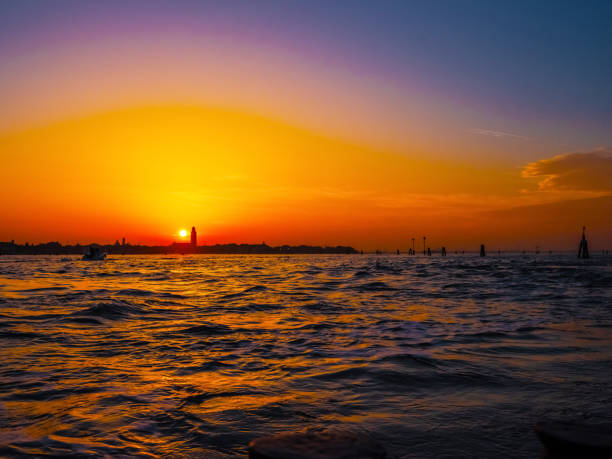 Venice, Italy. 29 october 2022. silhouettes of Venice at sunset in the bright warm orange-red rays of the setting sun. view from the water