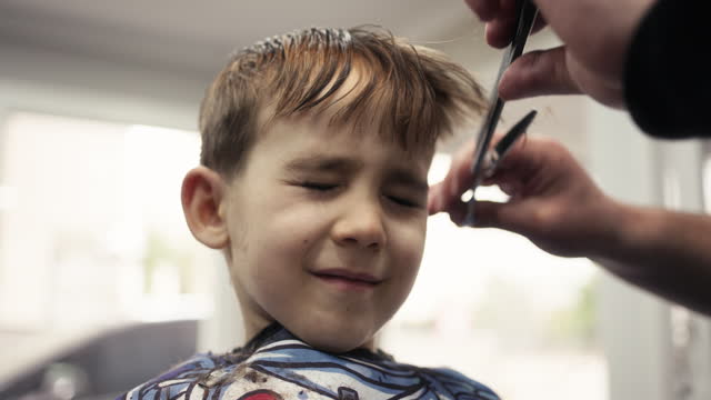 Child boy having a haircut at the barber shop