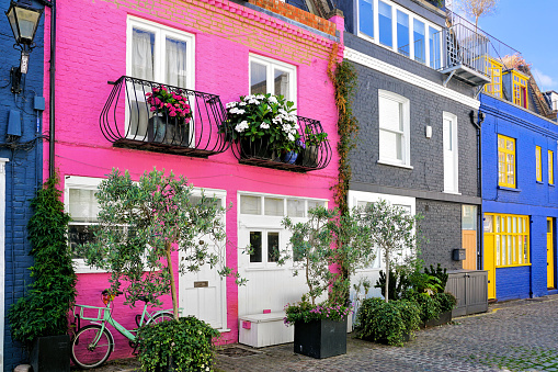 Colorful quaint houses of with flowers and bicycle, London, England