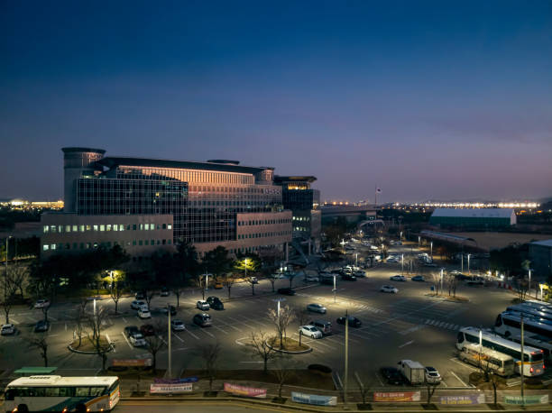 Incheon, S. Korea - Nov 27, 2019: Evening view of a government building, populated by various departments and agencies. Lots of car parking spaces in the foreground.